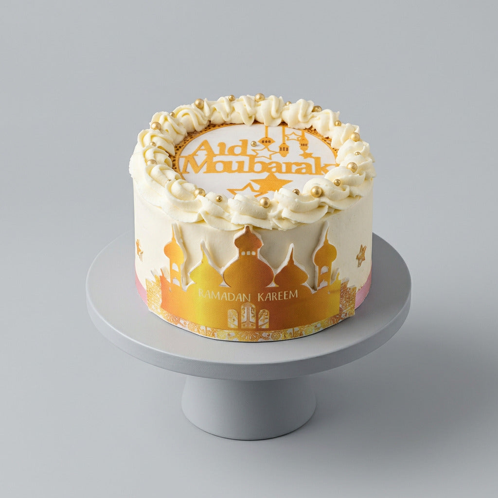 gâteau pour la fête de l’Aïd  décor blanc et doré , motif ville arabes aid moubarak dessus 