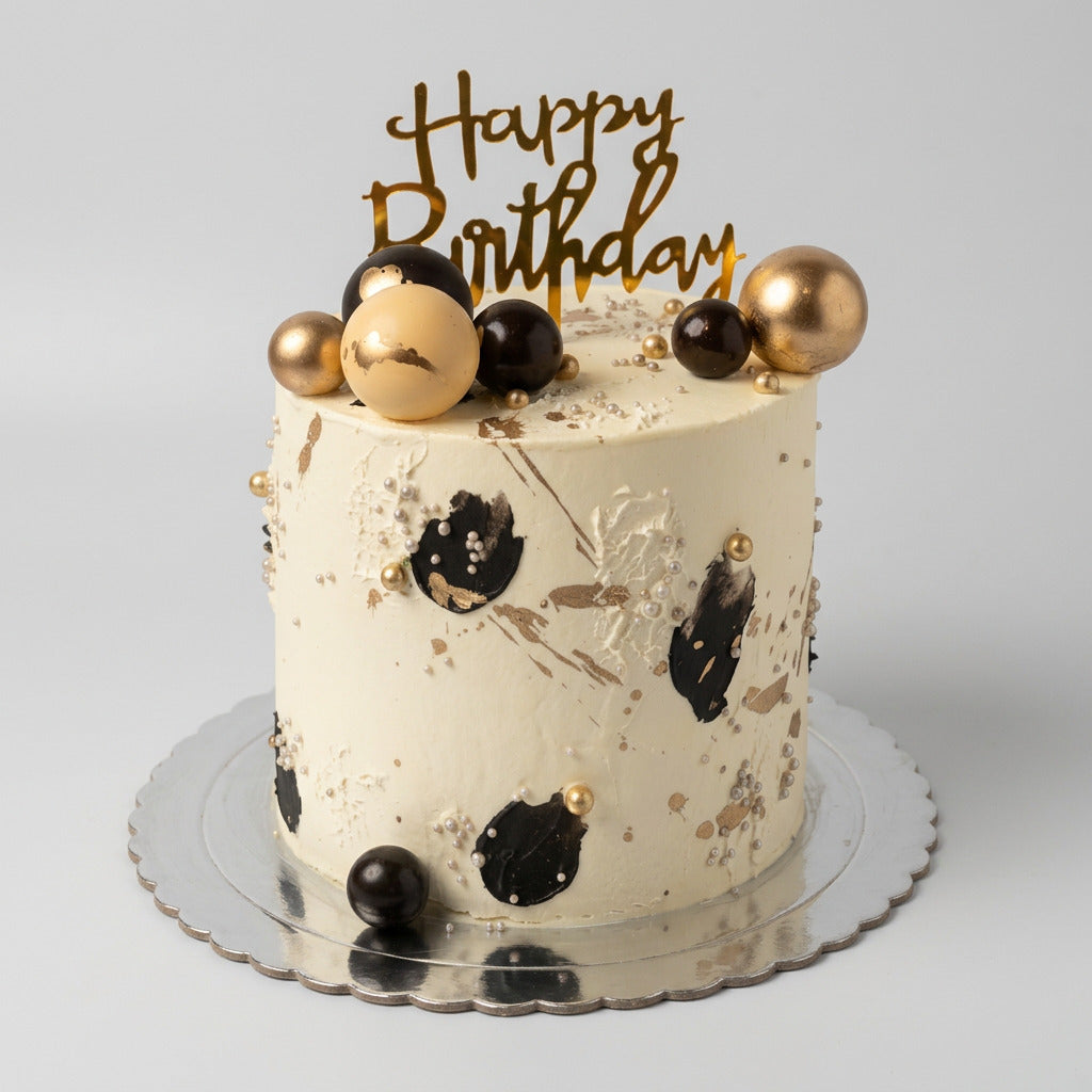 gâteau original art design avec des boules dorée et noir et des traces noir et dorée sur la gâteau 