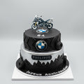 gâteau deux étages , forme pneu et dessous paysage , et dessus logo BMW et une moto dessus