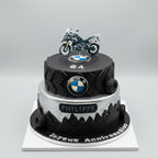 gâteau deux étages , forme pneu et dessous paysage , et dessus logo BMW et une moto dessus